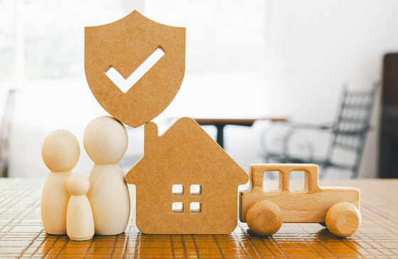 Image of a toy family, house, car and safety sign.