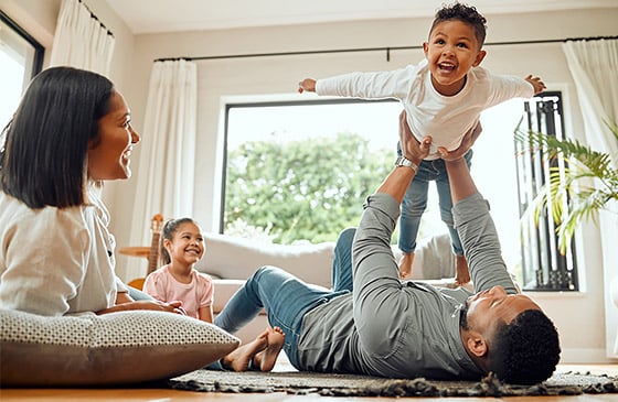 Family playing in living room of new house