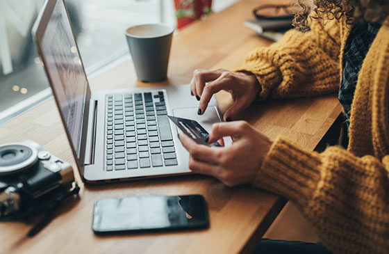 Woman scrolls through her computer as she used her credit card.