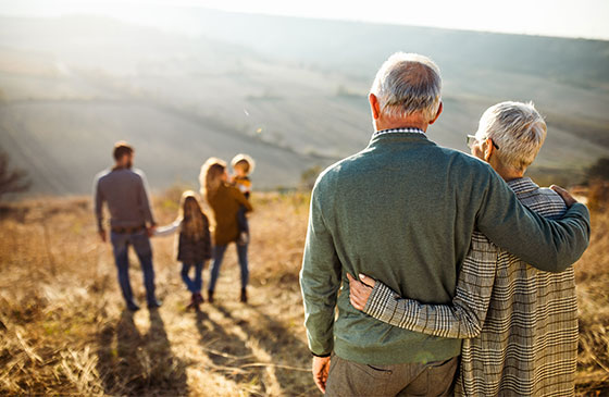 Elderly couple hugging and watching their children and grandchildren