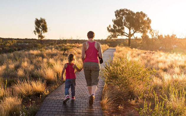 Mother and son walking together into the sunset