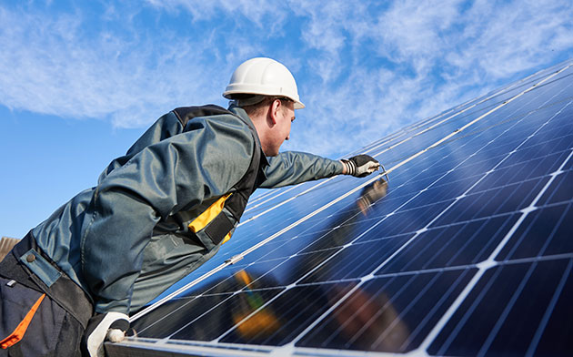 Man fixes a solar panel. 